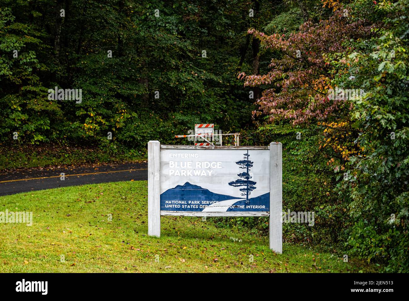 Laurel Springs, EE.UU. - 6 de octubre de 2021: Parque nacional de las montañas Blue Ridge en otoño con follaje de naranja en los árboles y signo de entrada parkway road Foto de stock