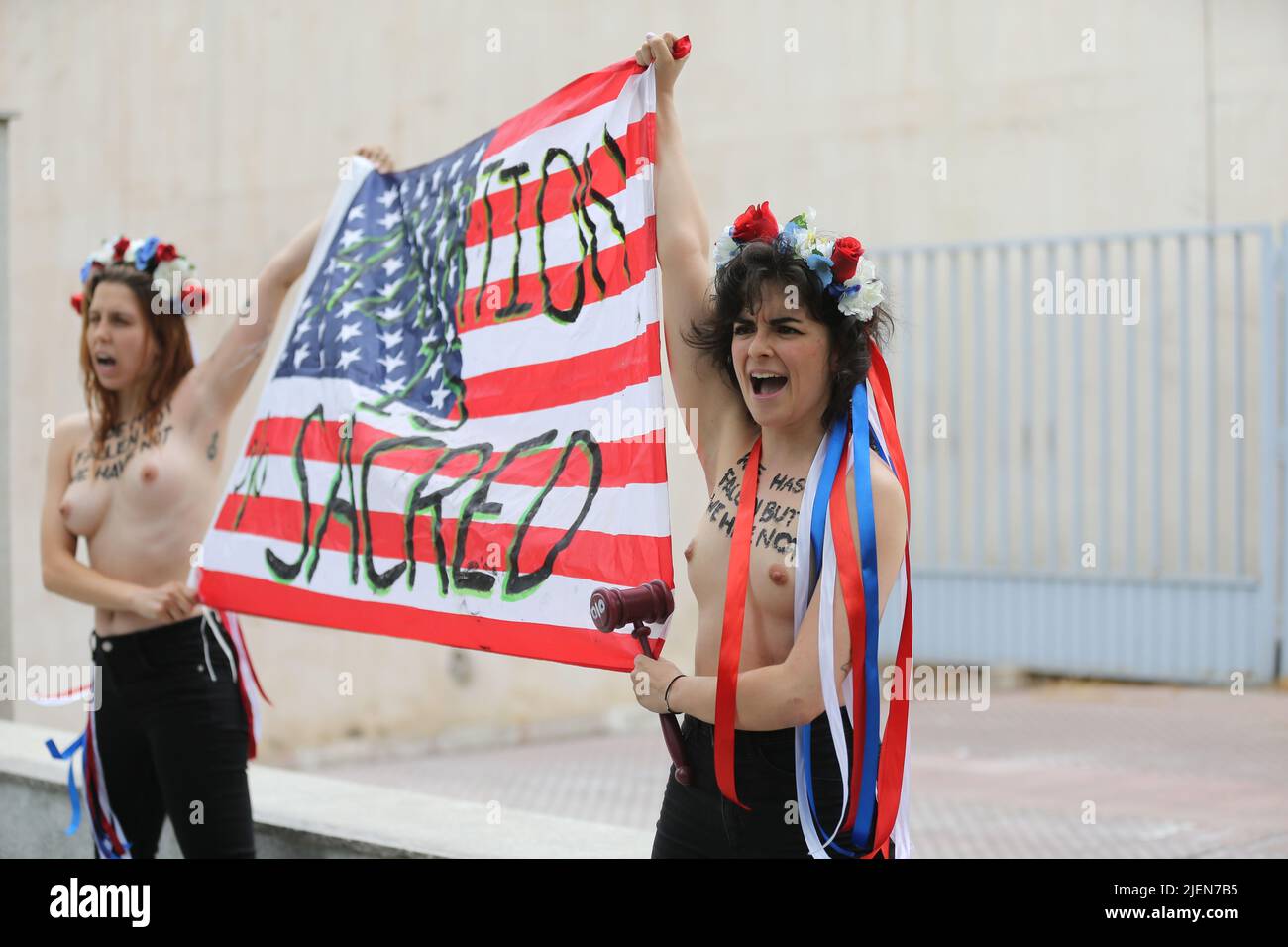 Madrid, España. 27th de junio de 2022. Miembros del grupo activista de mujeres Femen protestan con una pancarta que dice 'El aborto es sagrado' frente a la embajada de Estados Unidos en Madrid, España, el 27 de junio de 2022, tras la decisión de la Corte Suprema de Estados Unidos de poner fin al derecho constitucional al aborto. Crédito: Isabel Infantes/Alamy Live News Foto de stock