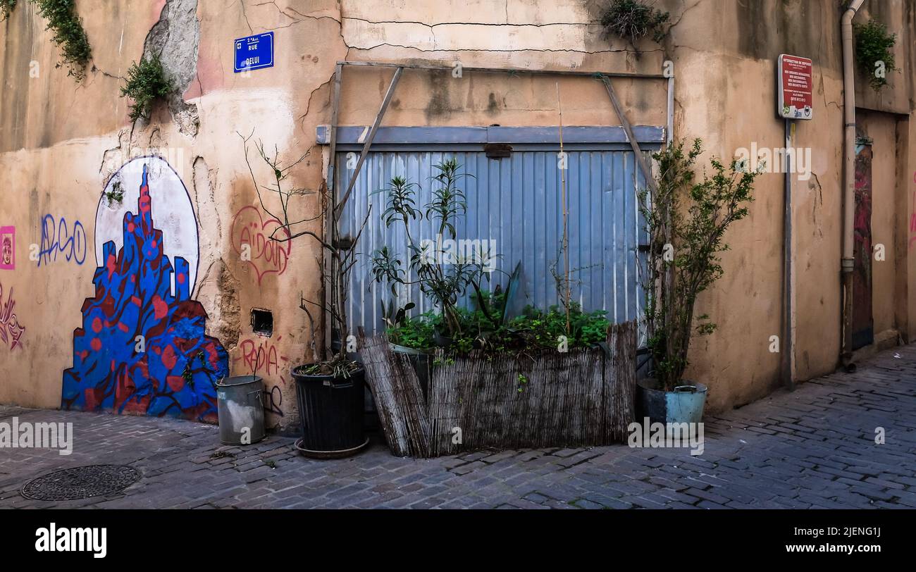Marsella, Francia, 2022 de mayo, vista de una puerta de garaje azul condenada bloqueada por plantas en macetas en el distrito de Le Panier Foto de stock