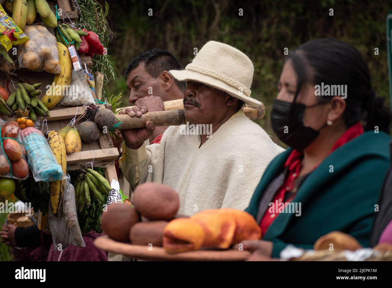 Hombre indígena llevando un castillo de comida como ofrenda al sol, Ipiales, Nariño. Foto de stock