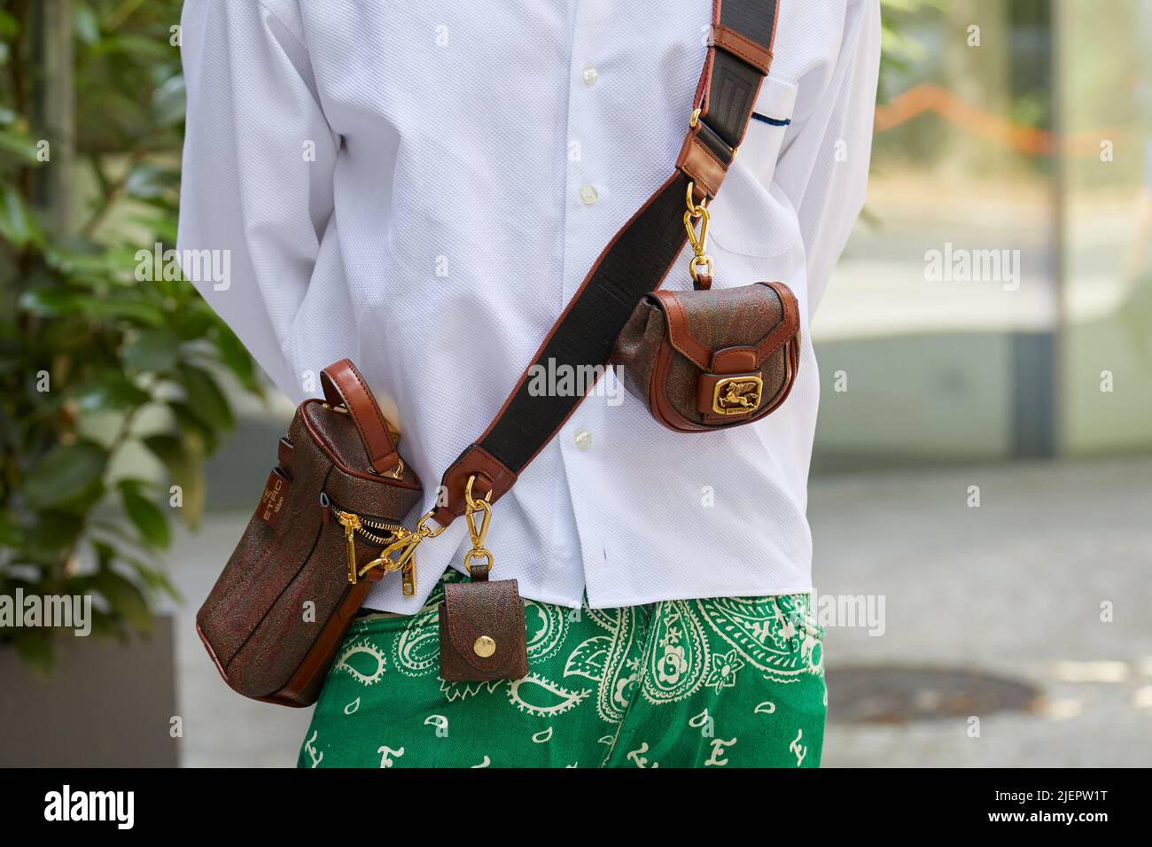 MILÁN, ITALIA - 19 DE JUNIO de 2022: Hombre con bolsa de cuero marrón Etro con detalles dorados antes del desfile de moda Etro, estilo urbano de la Semana de la Moda de Milán Foto de stock
