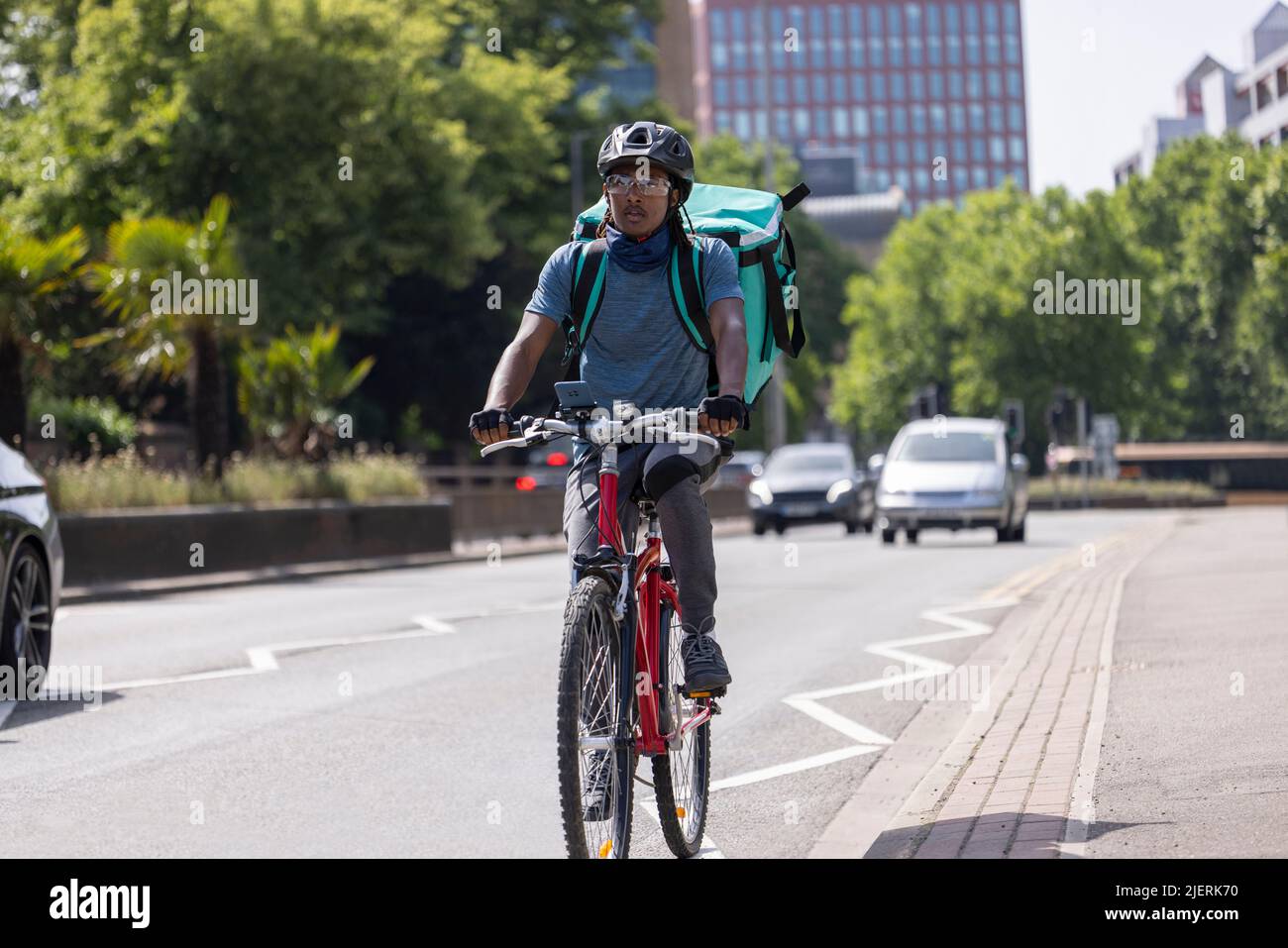 Servicio de mensajería en bicicleta que entrega comida en la ciudad Foto de stock