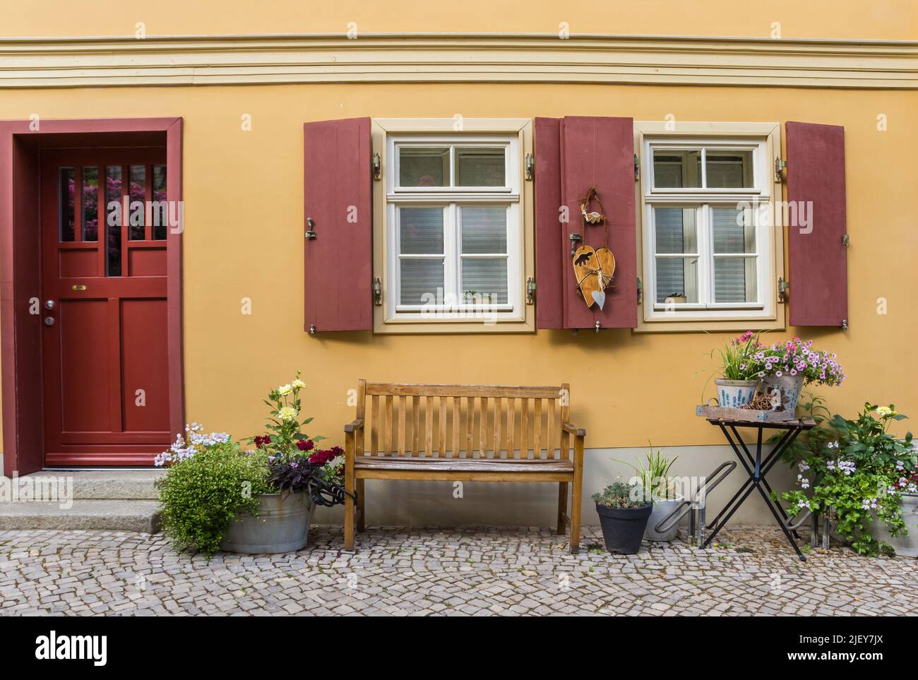 Banco y flores frente a una antigua casa en Quedlinburg, Alemania Foto de stock
