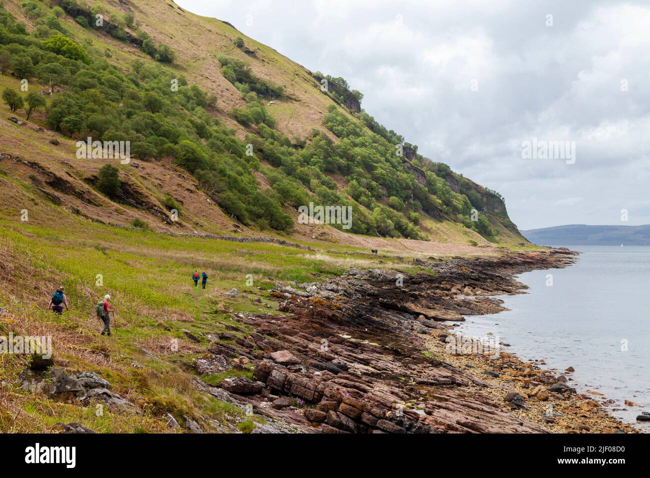 Gente caminando a lo largo de la costa entre Sannox y Lochranza en la Isla de Arran, Escocia. Foto de stock