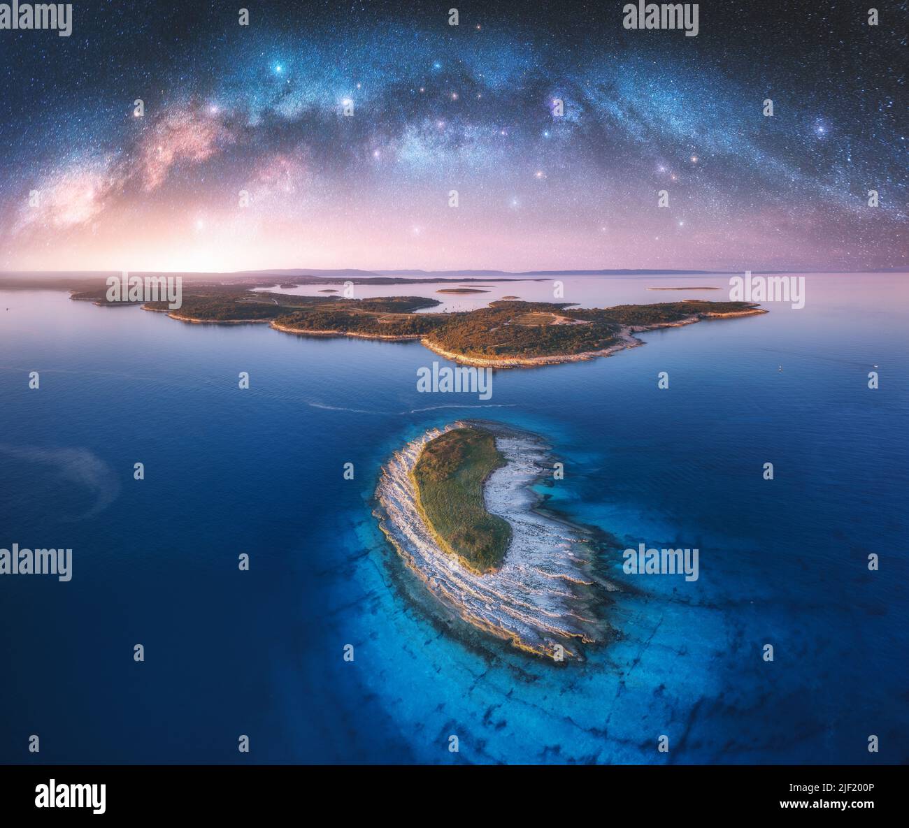Arco Vía Láctea y pequeña isla en el mar en la noche de verano Foto de stock