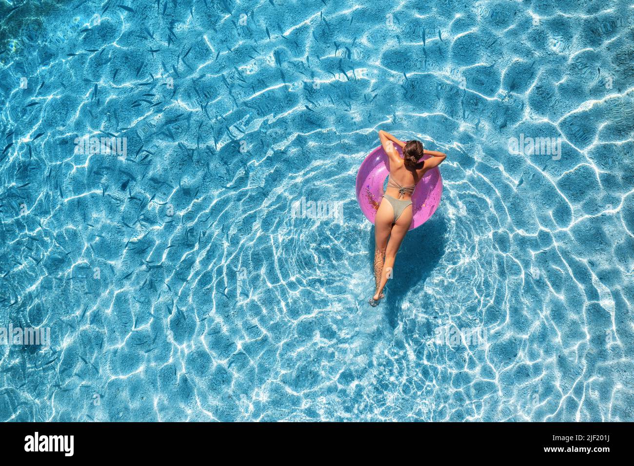 Vista aérea de una mujer nadando con anillo de natación rosa Foto de stock
