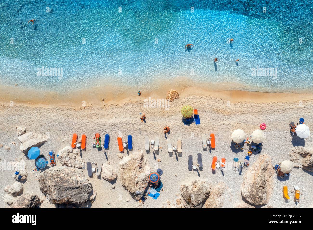 Vista aérea del mar azul, playa con sombrillas, rocas, agua Foto de stock