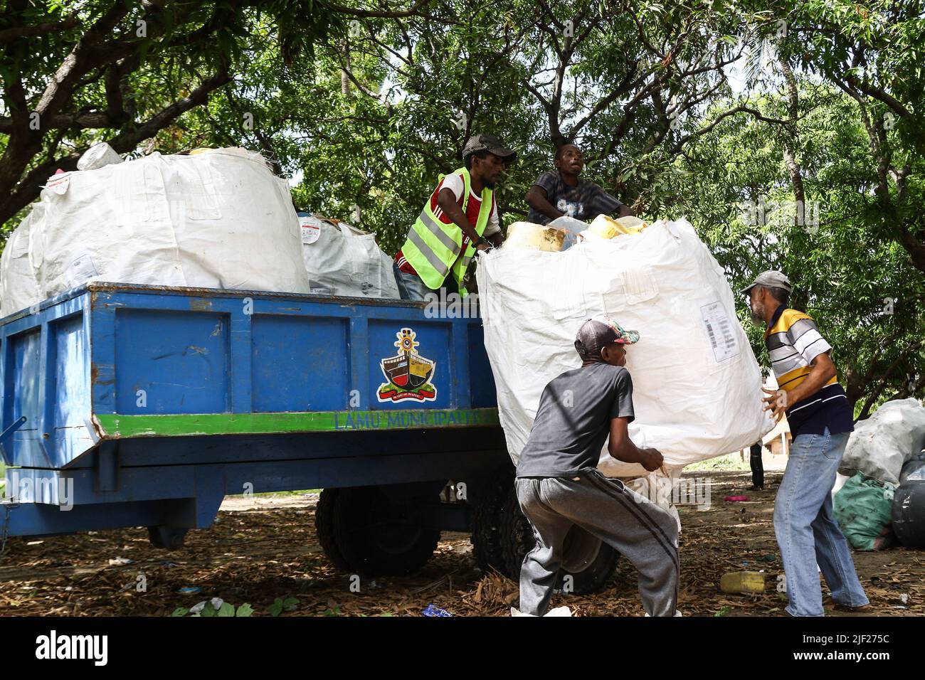 Los miembros de un grupo ambientalista comunitario, Weka Lamu Safi (Mantener Lamu Limpio), cargan en un remolque de tractor una semana de recolección de residuos plásticos recolectados dentro de la isla de Lamu antes de venderlos a la organización FlipFlopi para su reciclaje. La Organización FlipFlopi en 2019 construyó un velero casi enteramente de residuos plásticos reciclados recolectados en las orillas del Océano Índico. La contaminación causada por las actividades humanas ha afectado negativamente a los océanos. El Presidente de Kenia, Uhuru Kenyatta, en su discurso durante la conferencia oceánica en curso en Lisboa, Portugal, dijo que la contaminación plástica es enfermiza y contami Foto de stock