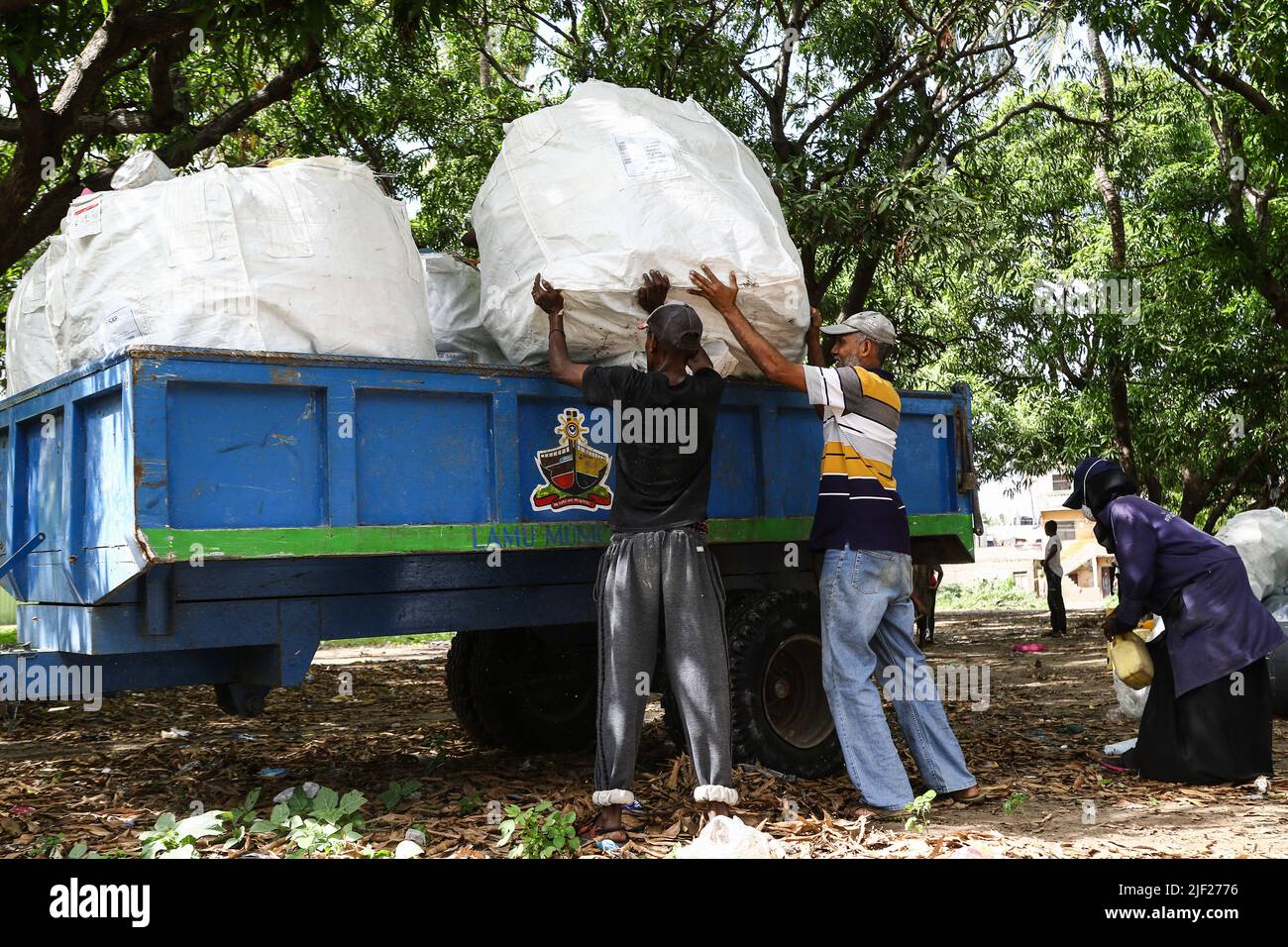 Los miembros de un grupo ambientalista comunitario, Weka Lamu Safi (Mantener Lamu Limpio), cargan en un remolque de tractor una semana de recolección de residuos plásticos recolectados dentro de la isla de Lamu antes de venderlos a la organización FlipFlopi para su reciclaje. La Organización FlipFlopi en 2019 construyó un velero casi enteramente de residuos plásticos reciclados recolectados en las orillas del Océano Índico. La contaminación causada por las actividades humanas ha afectado negativamente a los océanos. El Presidente de Kenia, Uhuru Kenyatta, en su discurso durante la conferencia oceánica en curso en Lisboa, Portugal, dijo que la contaminación plástica es enfermiza y contami Foto de stock