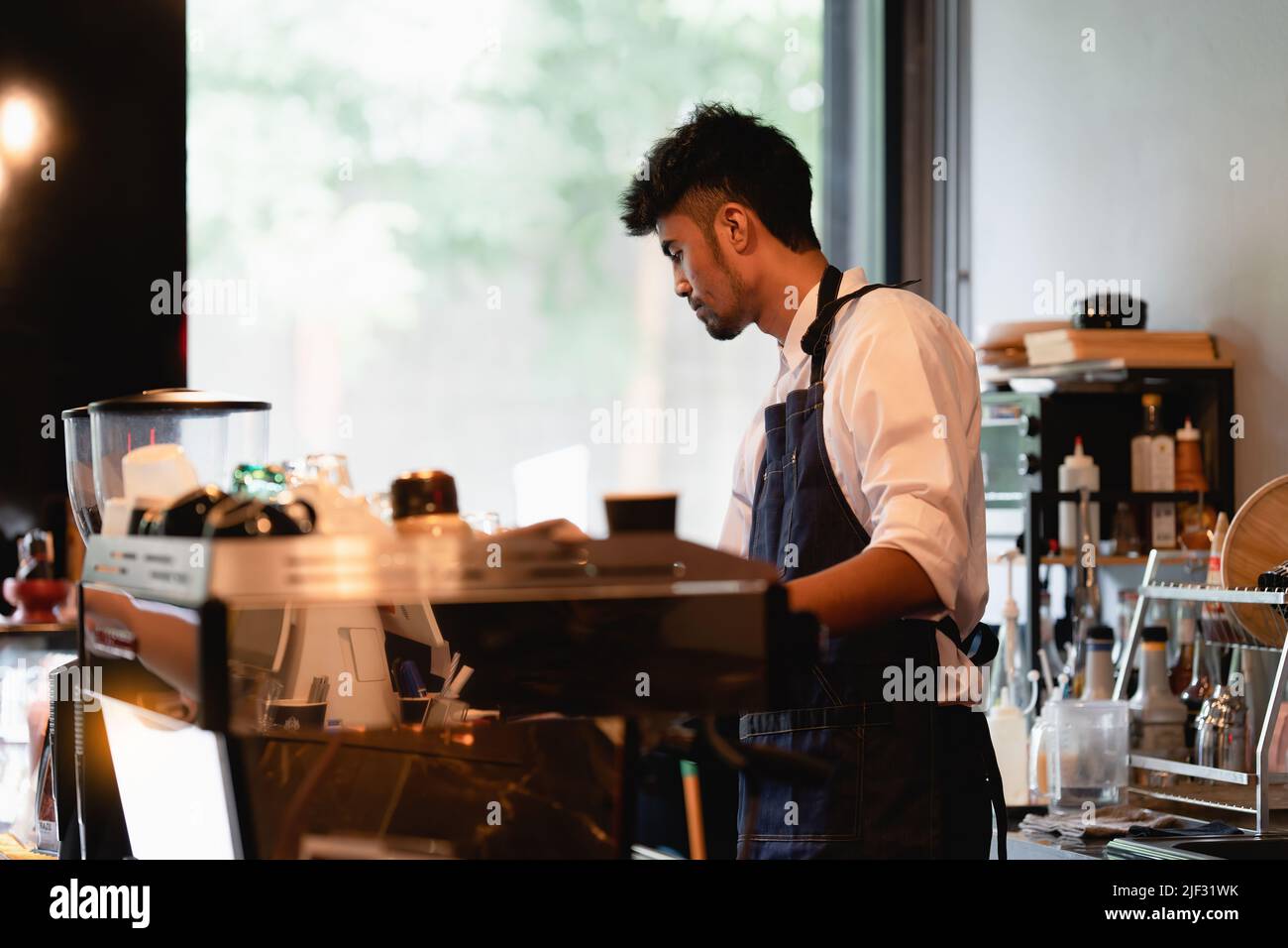 Propietario de un café asiático barista mientras el café está abierto. Concepto de negocio de vendedor emprendedor de PYME. Foto de stock