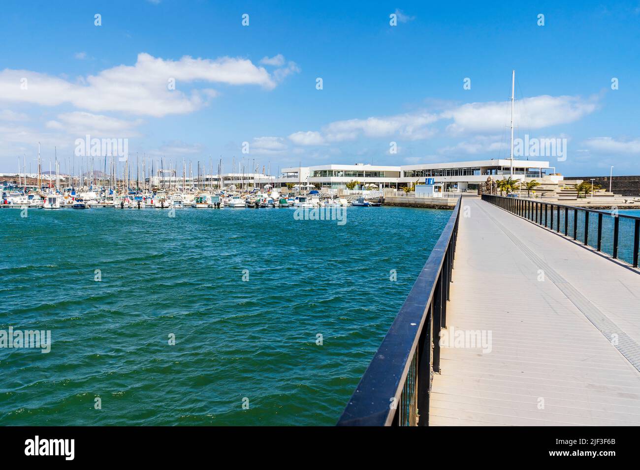 Puente peatonal, barcos y arquitectura moderna en el puerto deportivo de Arrecife, capital de Lanzarote, Islas Canarias, España Foto de stock