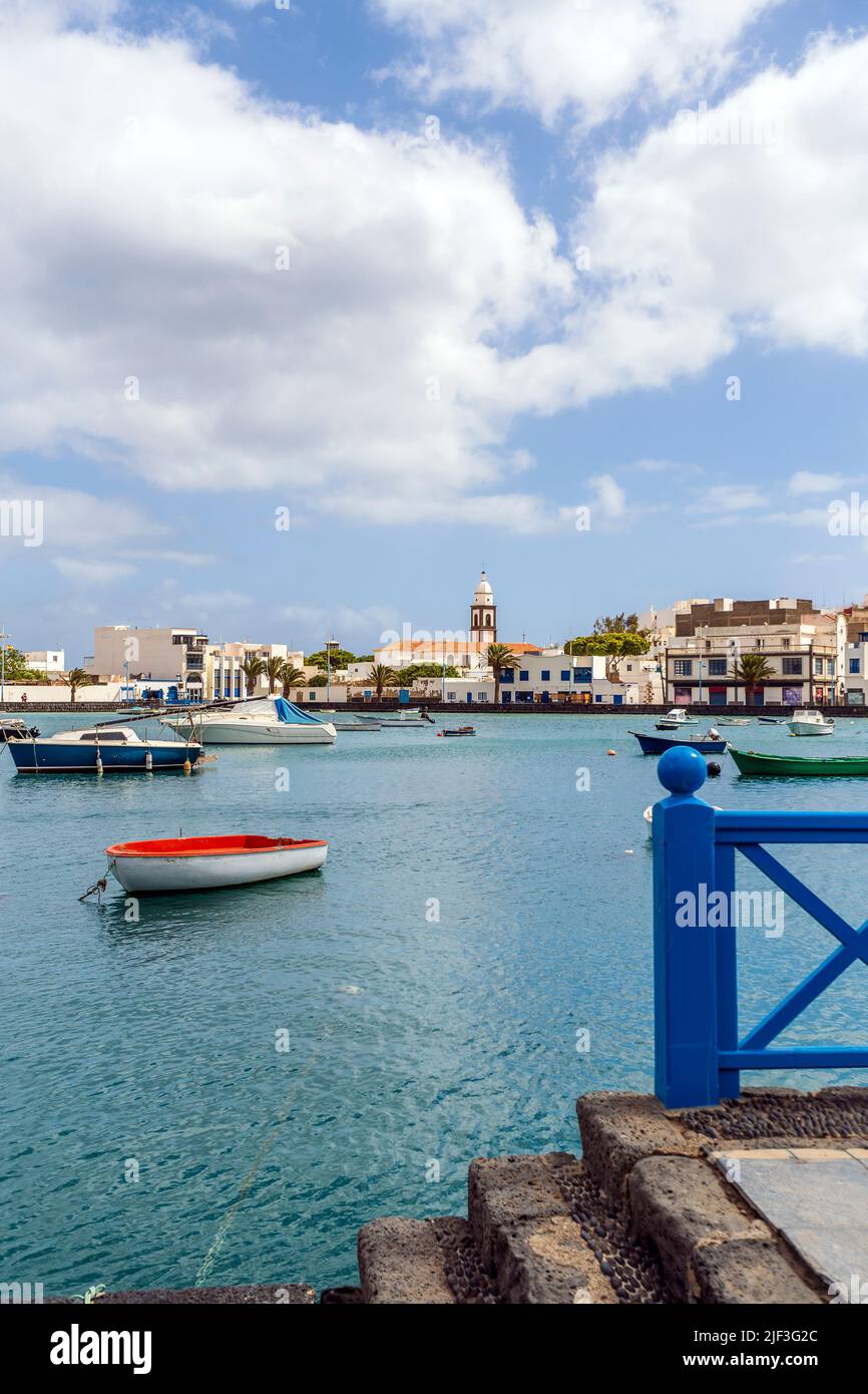 Hermoso muelle con arquitectura histórica y barcos en aguas azules en Arrecife, Lanzarote, Islas Canarias, España Foto de stock