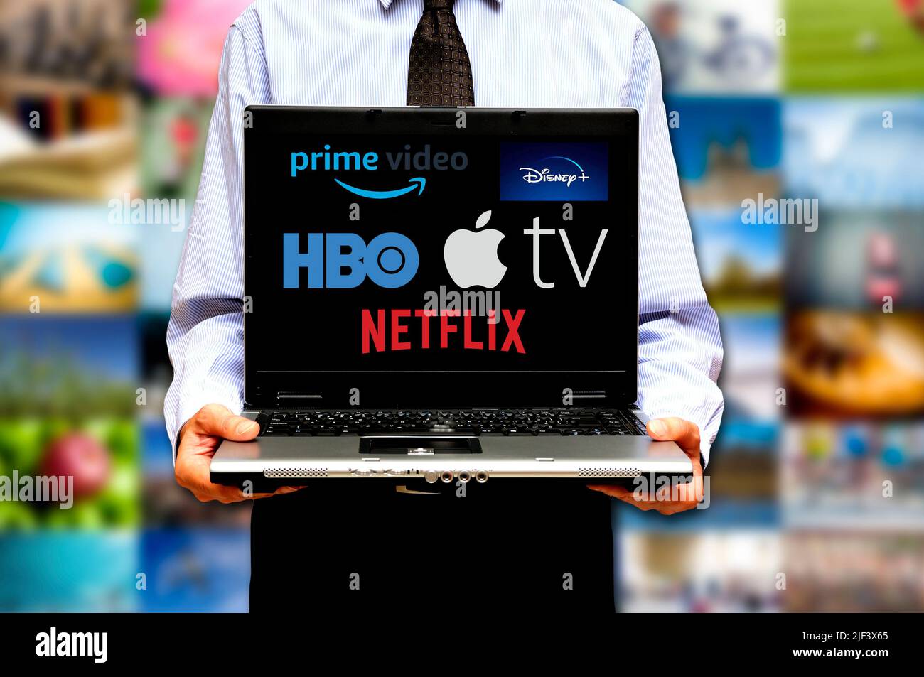 hombre con portátil y varios servicios de streaming de vídeo logotipo en la pantalla Foto de stock