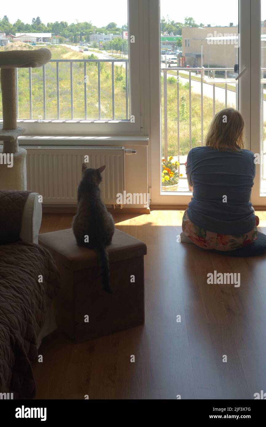 mujer sentada en el interior y meditando con su gato Foto de stock