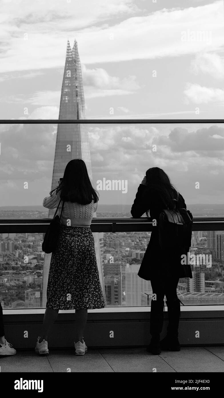 Parte trasera de dos turistas femeninas Tomando fotos del horizonte de Shard y Londres desde la plataforma de observación en el Skygarden en 20 Fenchurch Street, Londres Foto de stock