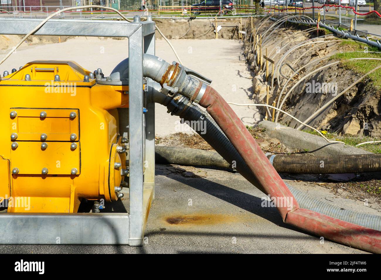 Bomba de agua eléctrica grande y portátil amarilla con manguera para  desagüe del pozo profundo de la fundación del edificio Fotografía de stock  - Alamy