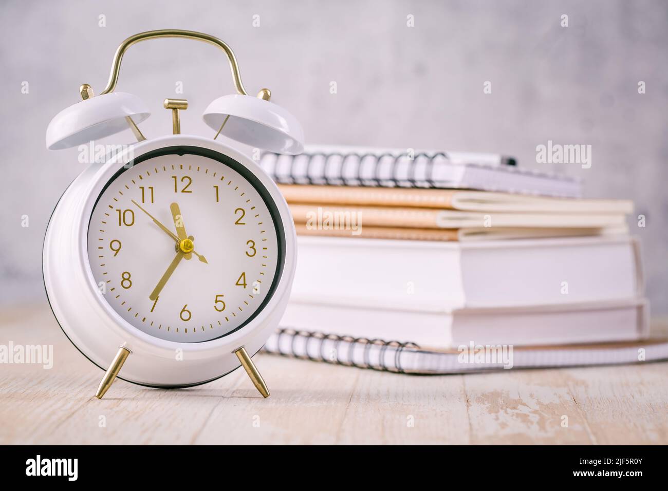 Concepto de gestión de tiempo para escolares y estudiantes. Libros con reloj Foto de stock