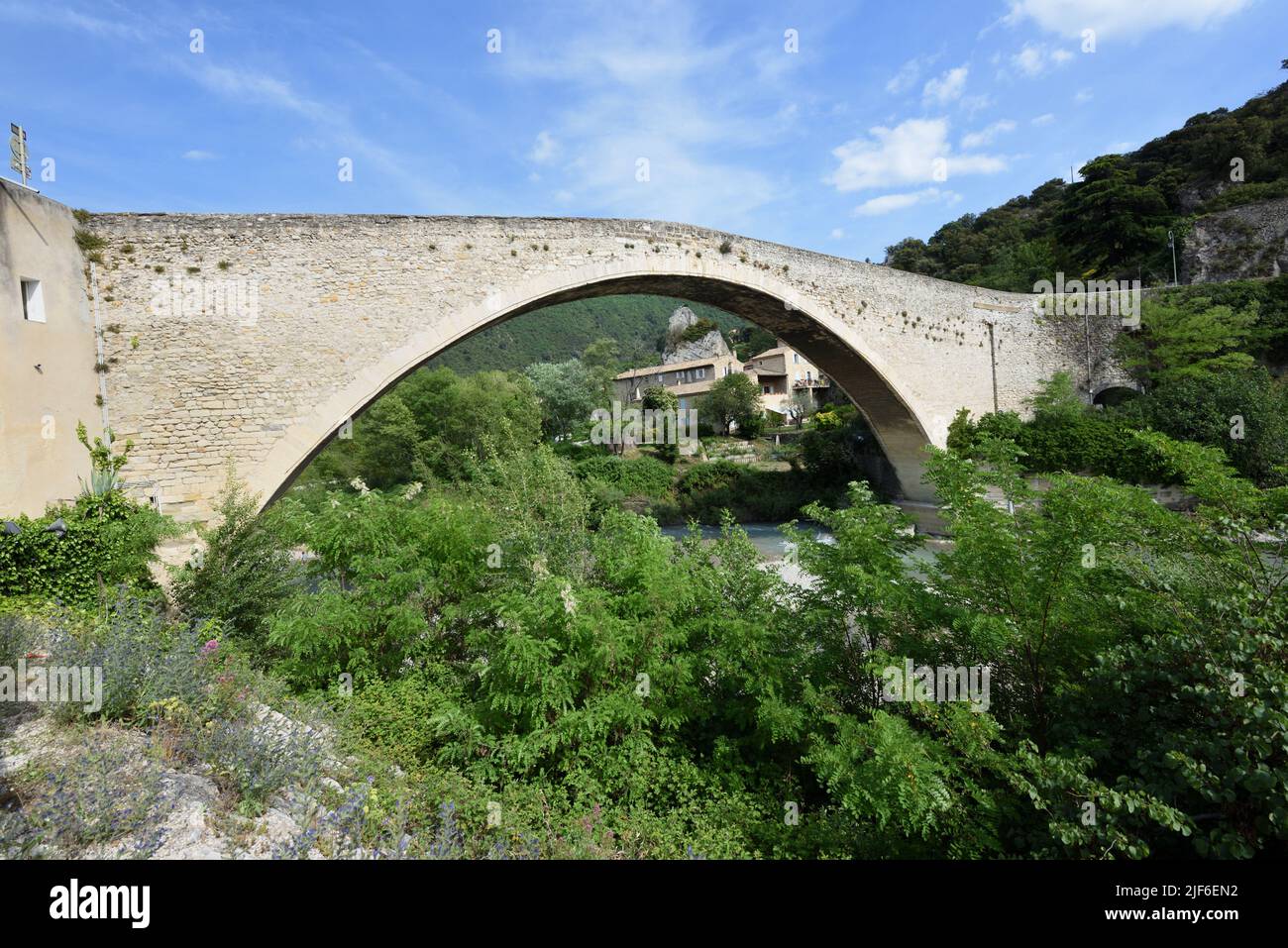 Single Span Puente Medieval, conocido como el Puente Romano, o Puente de Piedra Antiguo sobre el río Aigues Nyons Drôme Provenza Francia Foto de stock