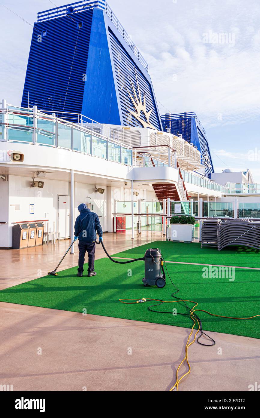 Un trabajador limpiando las cubiertas del crucero P&O Britannia temprano en la mañana mientras se acerca a Estocolmo, Suecia Foto de stock