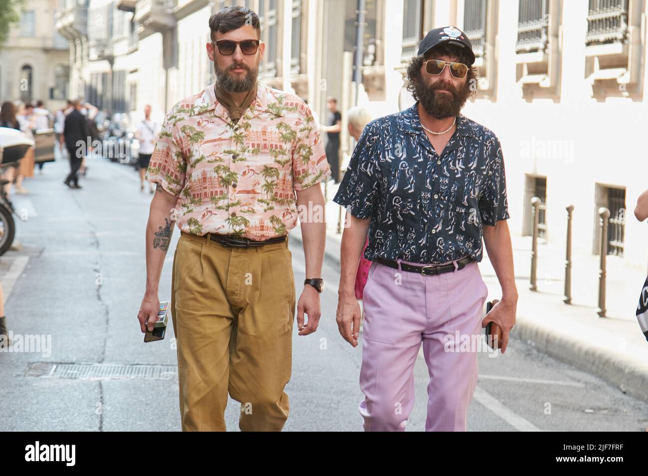 MILÁN, ITALIA - 20 DE JUNIO de 2022: Hombres de color mostaza y pantalones púrpura pálido antes del desfile Giorgio Armani, Milán Fashion Week Street Foto de stock