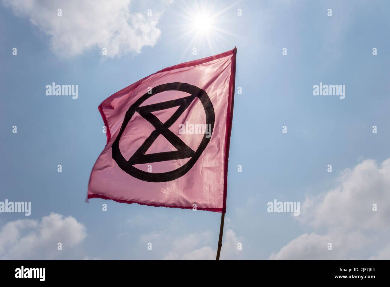 Extinción Bandera de Rebelión, con símbolo de reloj de arena, bajo un sol brillante. Calentamiento global, activismo por el cambio climático. Voló durante la protesta de aguas residuales en Southend Foto de stock