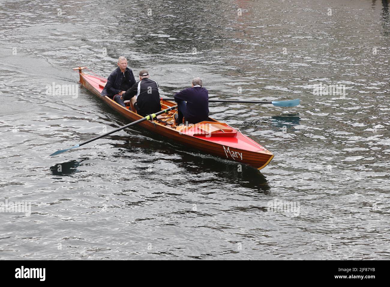 Copenhague, Dinamarca - 14 de junio de 2022: Tres hombres en un bote de remo utilizando el canal para hacer ejercicio. Foto de stock