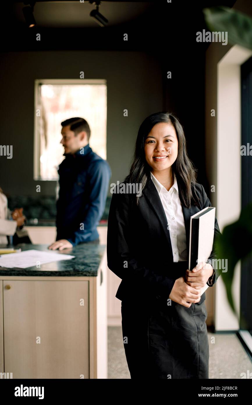 Retrato de un sonriente agente inmobiliario de pie en la casa nueva Foto de stock