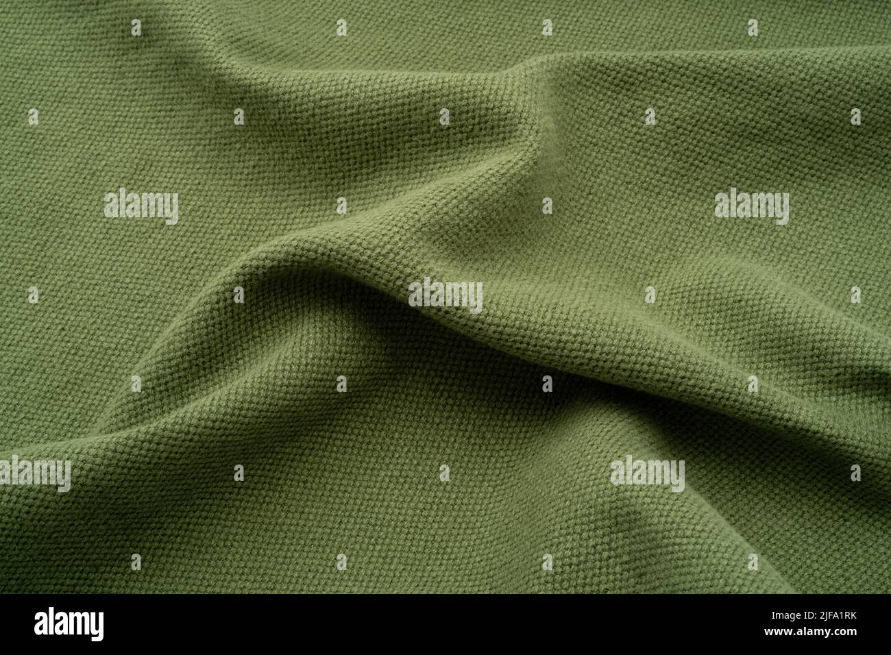 Fondo de tela texturizada. Un lino fruncido de color verde oliva. Foto de stock