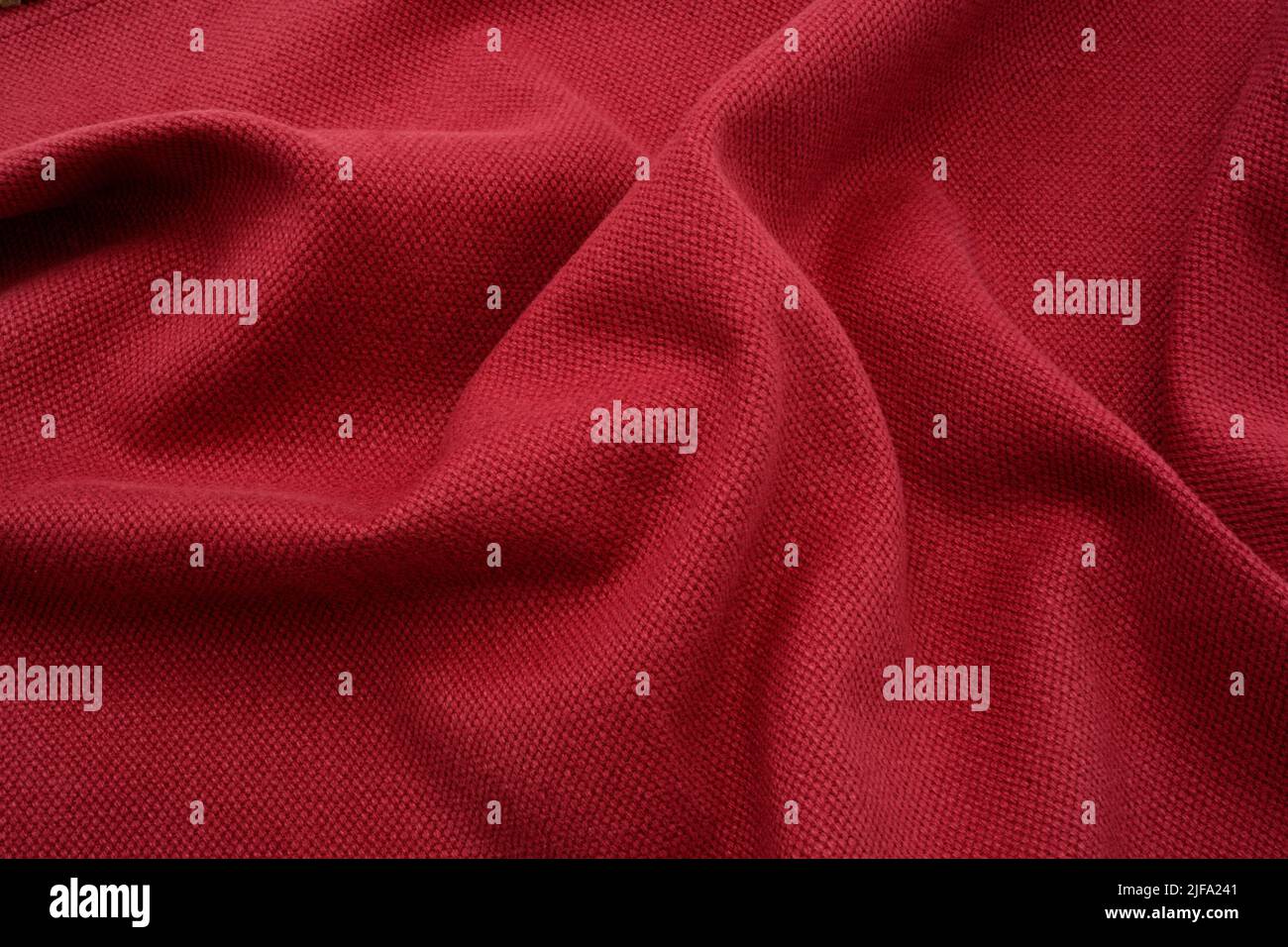Fondo de tela texturizada. Un tejido de lino rojo fruncido. Foto de stock