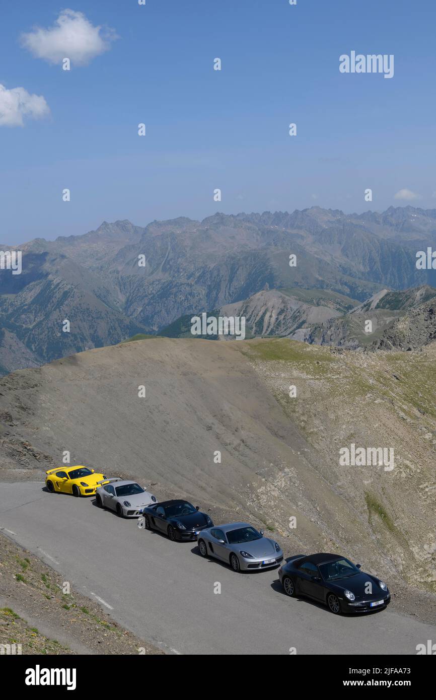 Vista de cinco coches deportivos Porsche en carretera de montaña de 2802 metros de altura, la carretera asfaltada más alta de los Alpes, en el fondo alto paisaje alpino de montaña Foto de stock