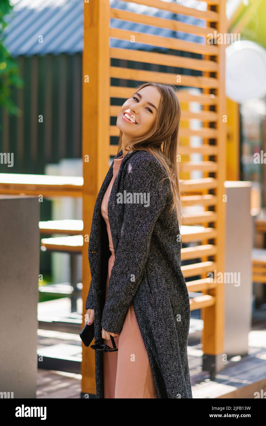 Una joven feliz y encantadora disfruta de un paseo primaveral por la ciudad Foto de stock