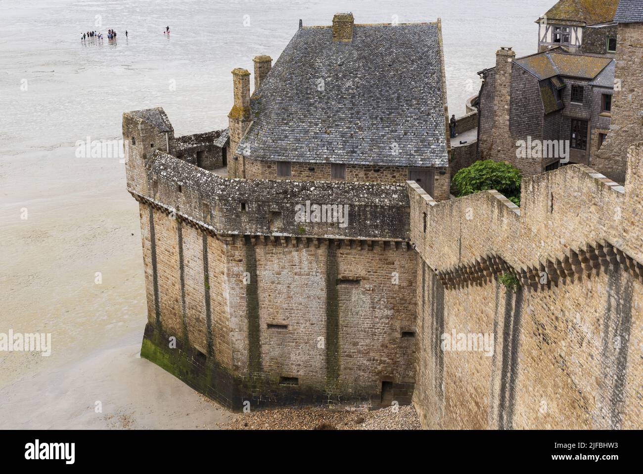 Francia, La Mancha, Mont Saint Michel Bay catalogado como Patrimonio de la Humanidad por la UNESCO, la abadía de Mont Saint Michel, murallas, marea baja, los excursionistas que cruzan la bahía a pie Foto de stock