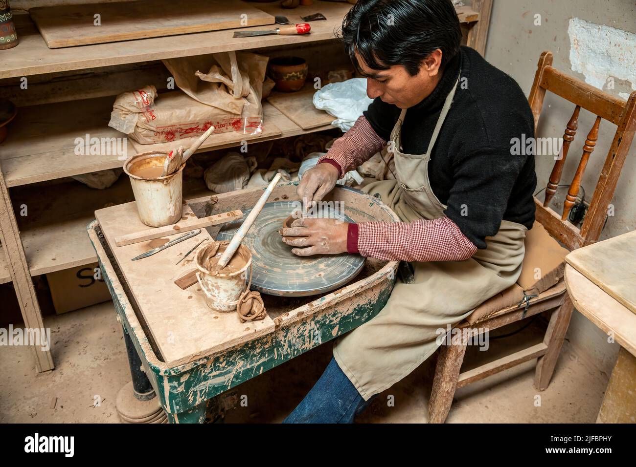 Hombre artesano trabajando en la rueda del alfarero, Seminario Ceramics, Urubamba, Cusco, Perú Foto de stock