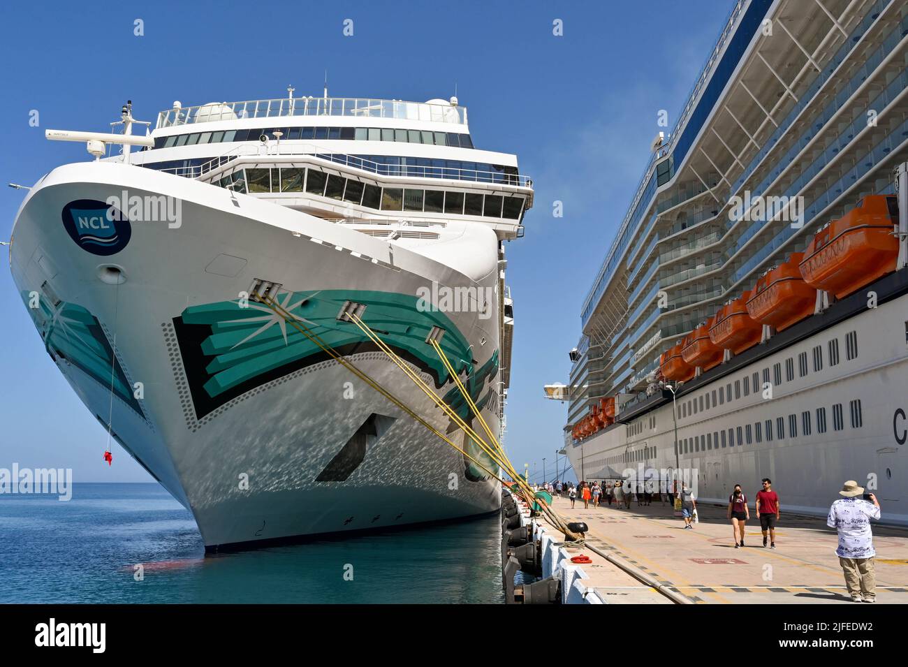 Kusadasi, Turquía - Junio Mayo 2022: Pasajeros caminando entre dos cruceros  en el puerto. A la izquierda está el crucero Norwegian Jade Fotografía de  stock - Alamy