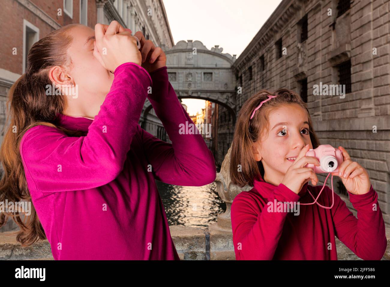 Una pareja de chicas pequeñas tomando fotografías con la cámara de fotos de juguete en el Puente de los Suspiros, Venecia Foto de stock