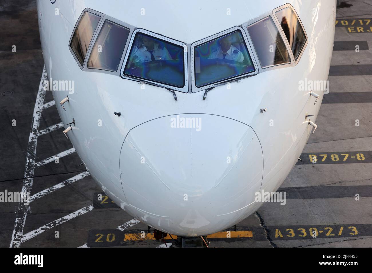 Los pilotos son vistos en la cabina de un avión mientras se sienta en el asfalto del Aeropuerto Internacional John F. Kennedy el fin de semana del 4th de julio en Queens, Ciudad de Nueva York, EE.UU., 2 de julio de 2022. REUTERS/Andrew Kelly Foto de stock