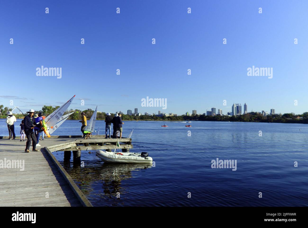Gente que navega yates de control remoto de juguetes, río Swan, con Perth CBD en el fondo, Maylands, Perth, Australia Occidental. Sin RM ni PR Foto de stock