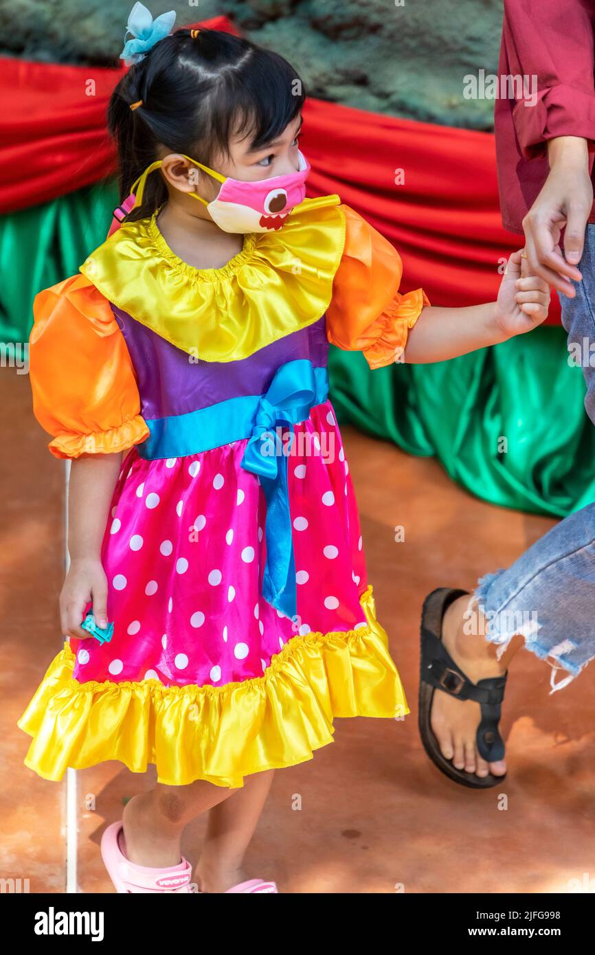 Niña tailandesa joven en vestido de fiesta con facemask, Pattaya, Chon Buri, Tailandia Foto de stock