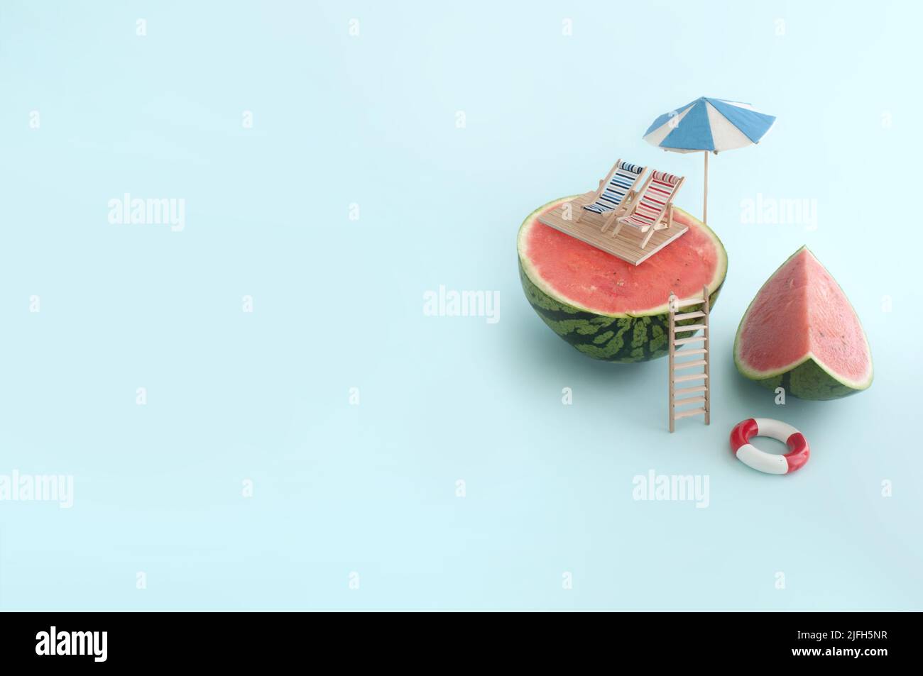 Concepto de vacaciones de verano; tumbonas y sombrilla en la parte superior de una sandía, con piscina abajo Foto de stock