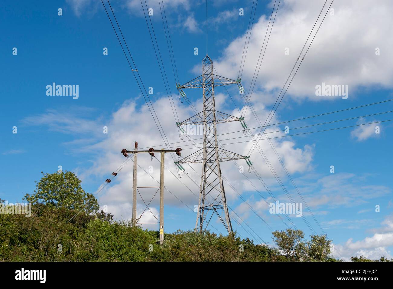 Los postes de la electricidad contra un cielo azul Foto de stock