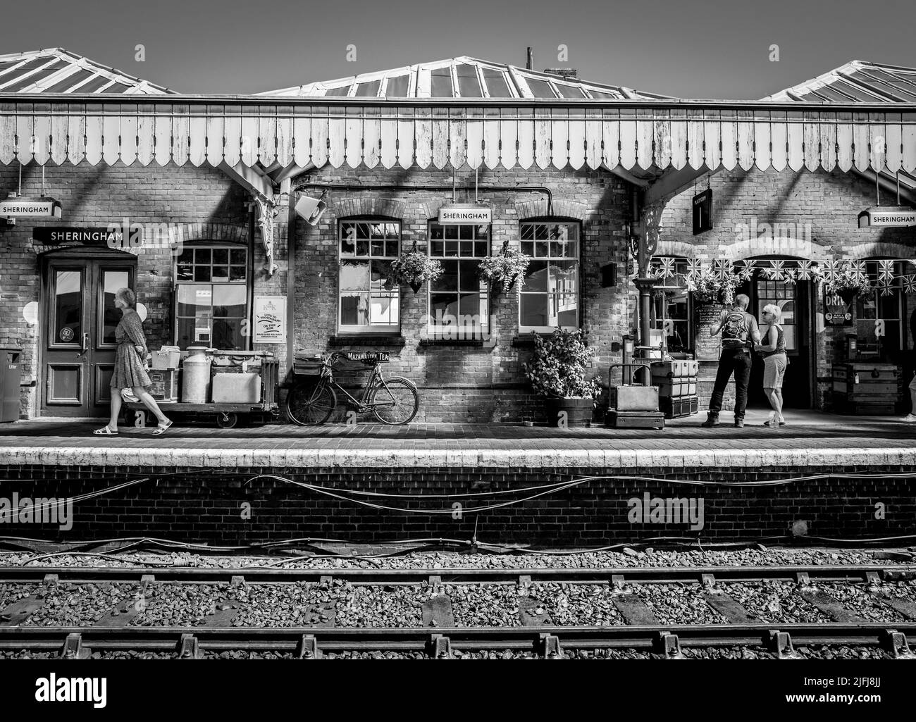 Pasajeros y turistas en la plataforma en la histórica estación ferroviaria de Sheringham que es parte de la línea ferroviaria North Norfolk. Foto de stock