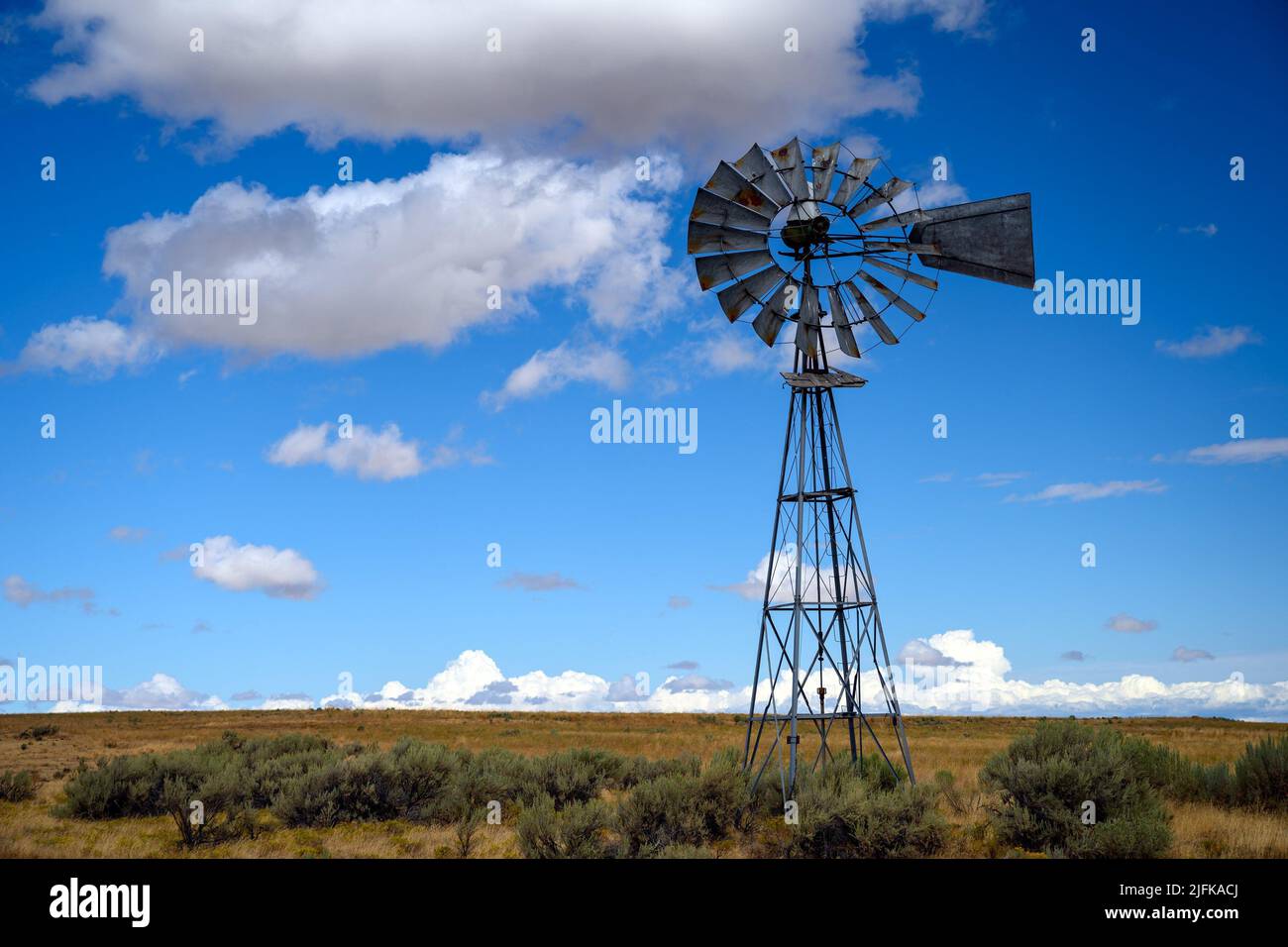 Antiguo molino de viento de granja del suroeste en algún lugar en el desierto en California, Estados Unidos de América. Foto de stock