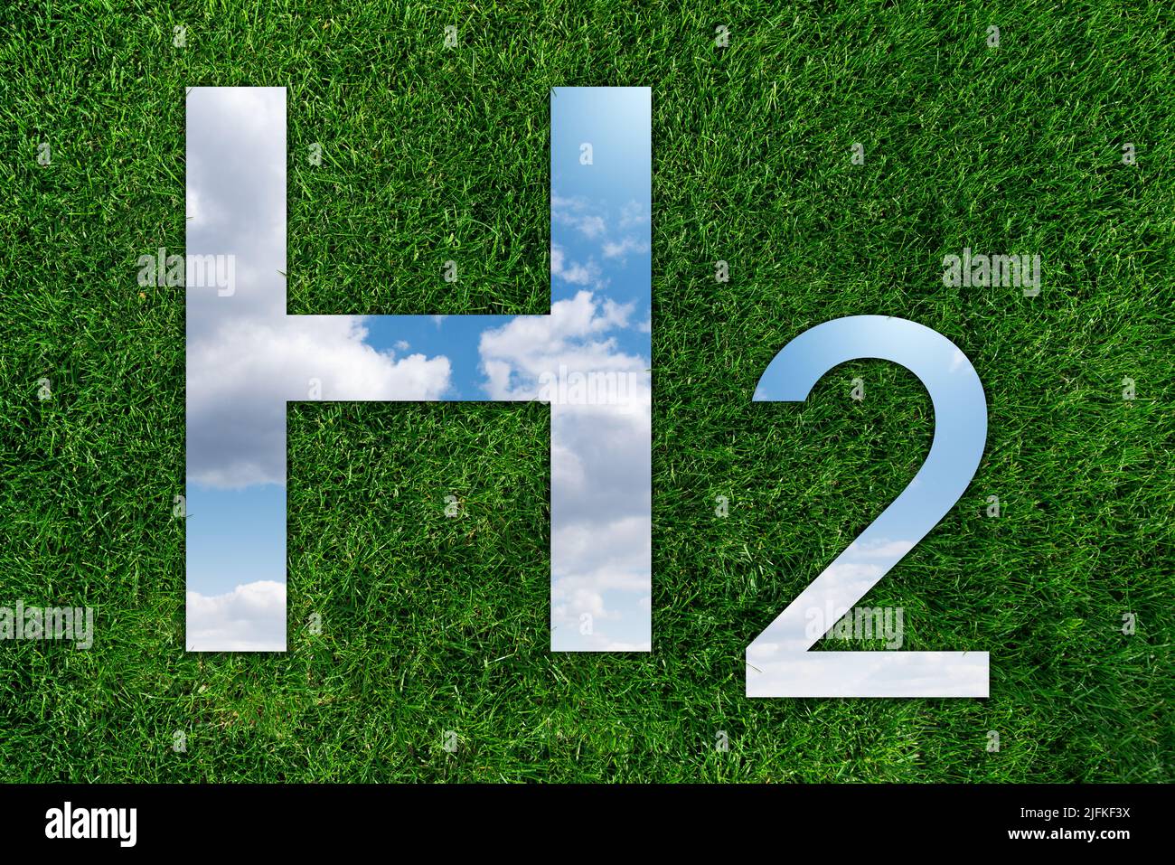 Espejo en forma de fórmula de hidrógeno H2 sobre hierba verde. Reflexión del cielo. Concepto de obtención de hidrógeno verde a partir de fuentes de energía renovables Foto de stock