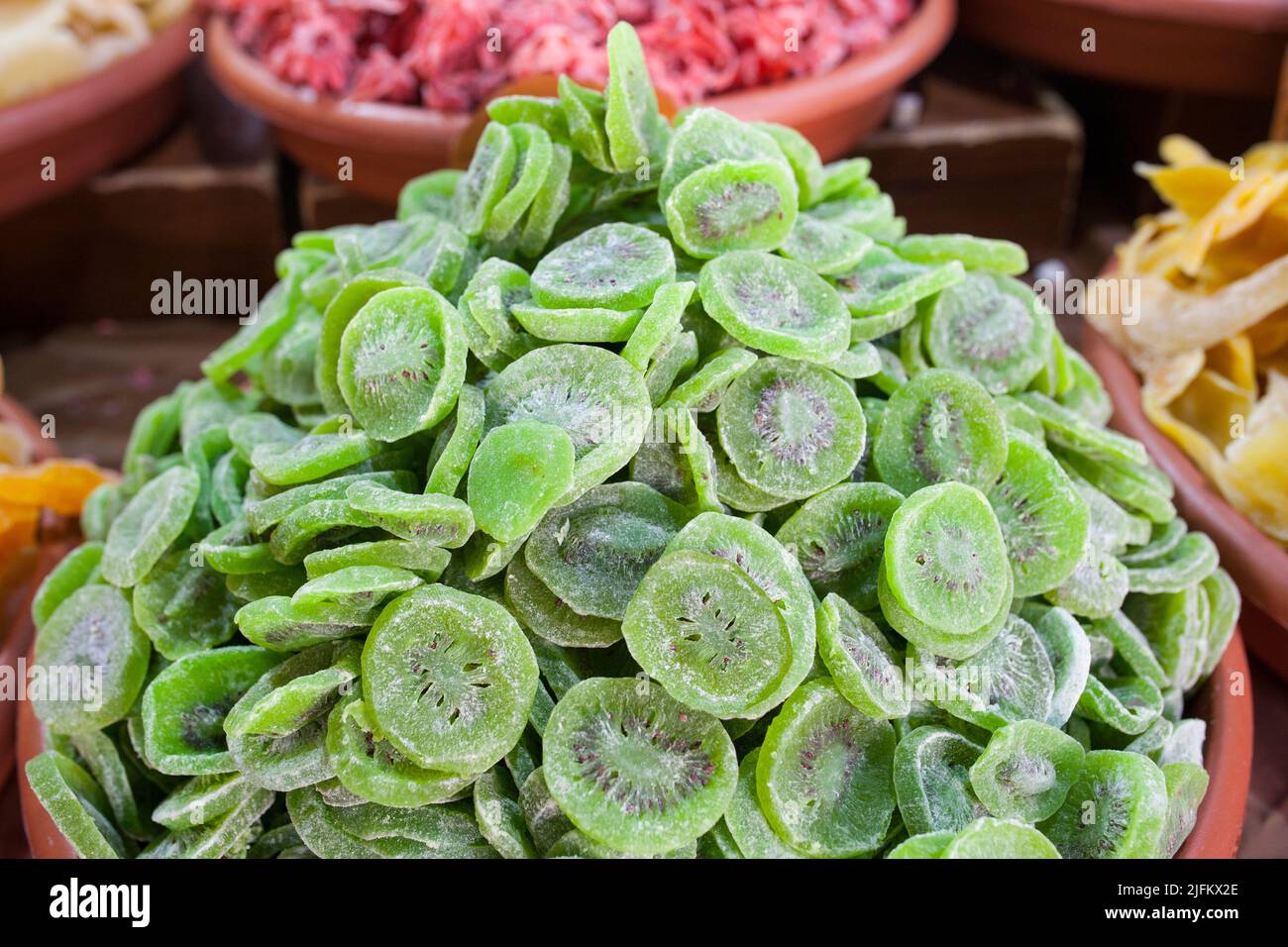 Tazón con kiwis secos. Los cortes se muestran en el puesto del mercado callejero. Foto de stock
