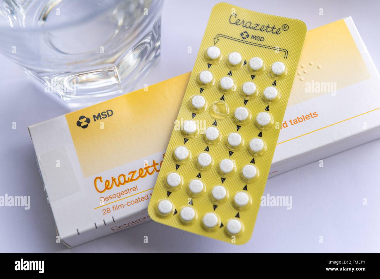 Cerazette Desogestrel Caja de tabletas anticonceptivas, envase blíster y un vaso de agua. ESTO ES UNA IMAGEN, NO EL PRODUCTO. Foto de stock