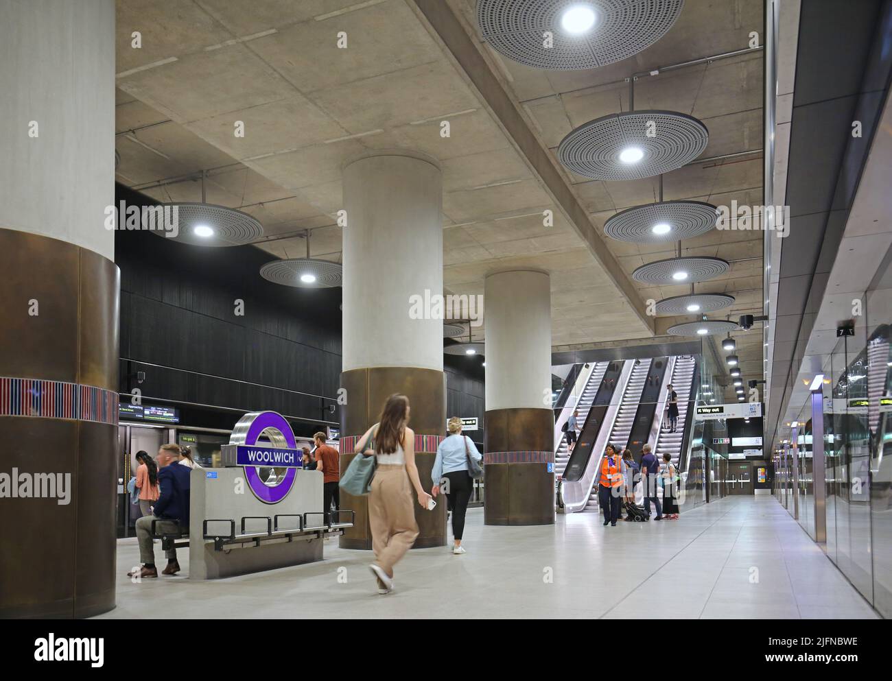 Londres, Reino Unido. Estación Woolwich en la recién inaugurada red de metro Elizabeth Line (tren cruzado). A nivel de la plataforma, muestra el tren y las escaleras mecánicas. Foto de stock