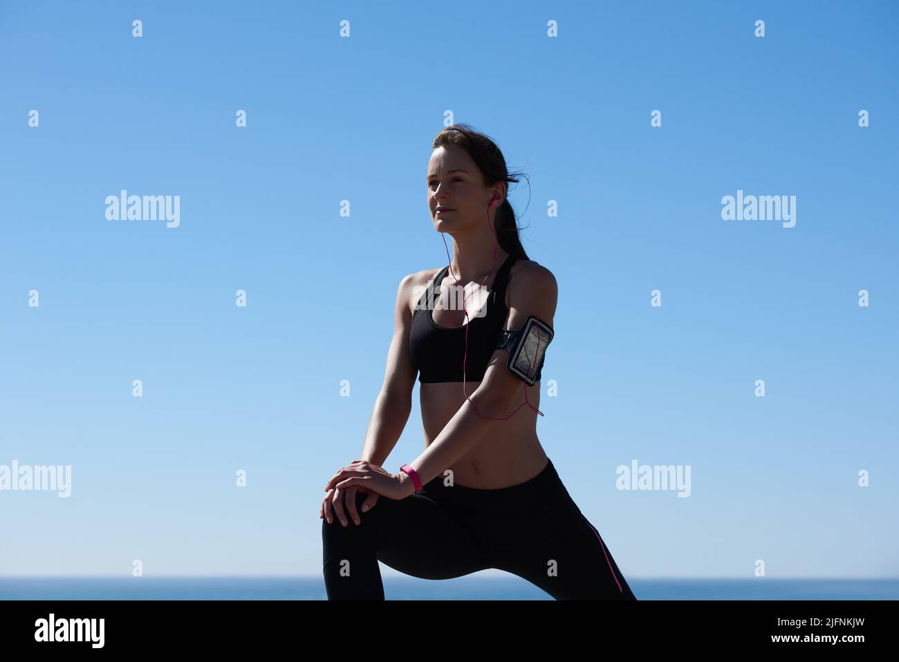 Levantándose. Fotografía de una atractiva atleta joven haciendo ejercicio al aire libre. Foto de stock