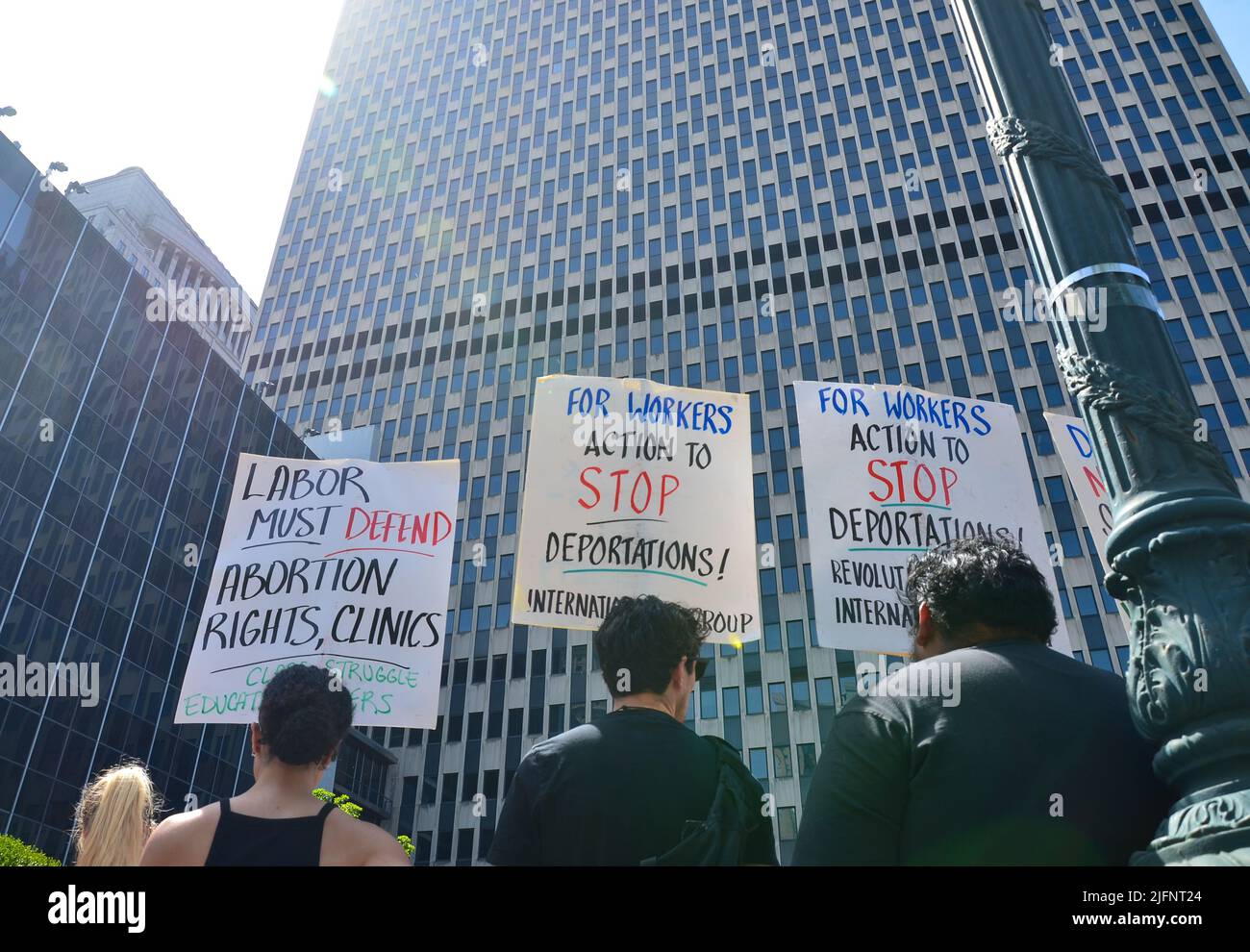 Activistas sostienen carteles frente a 26 Federal Plaza en la ciudad de Nueva York para exigir derechos reproductivos para todos los inmigrantes, el 4 de julio de 2022. Foto de stock