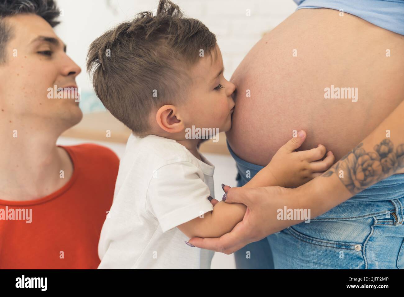 Ya te amo, bebé, niño besando el vientre de su madre embarazada. Fotografía de alta calidad Foto de stock