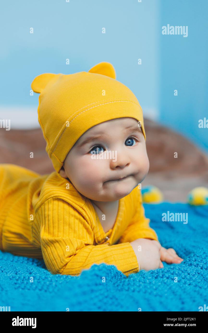 Aprobación corazón perdido Elaborar Un niño pequeño de 4-5 meses de edad se acuesta en una cama con ropa  amarilla. El niño comienza a sostener su cabeza. Ropa de bebé Fotografía de  stock - Alamy